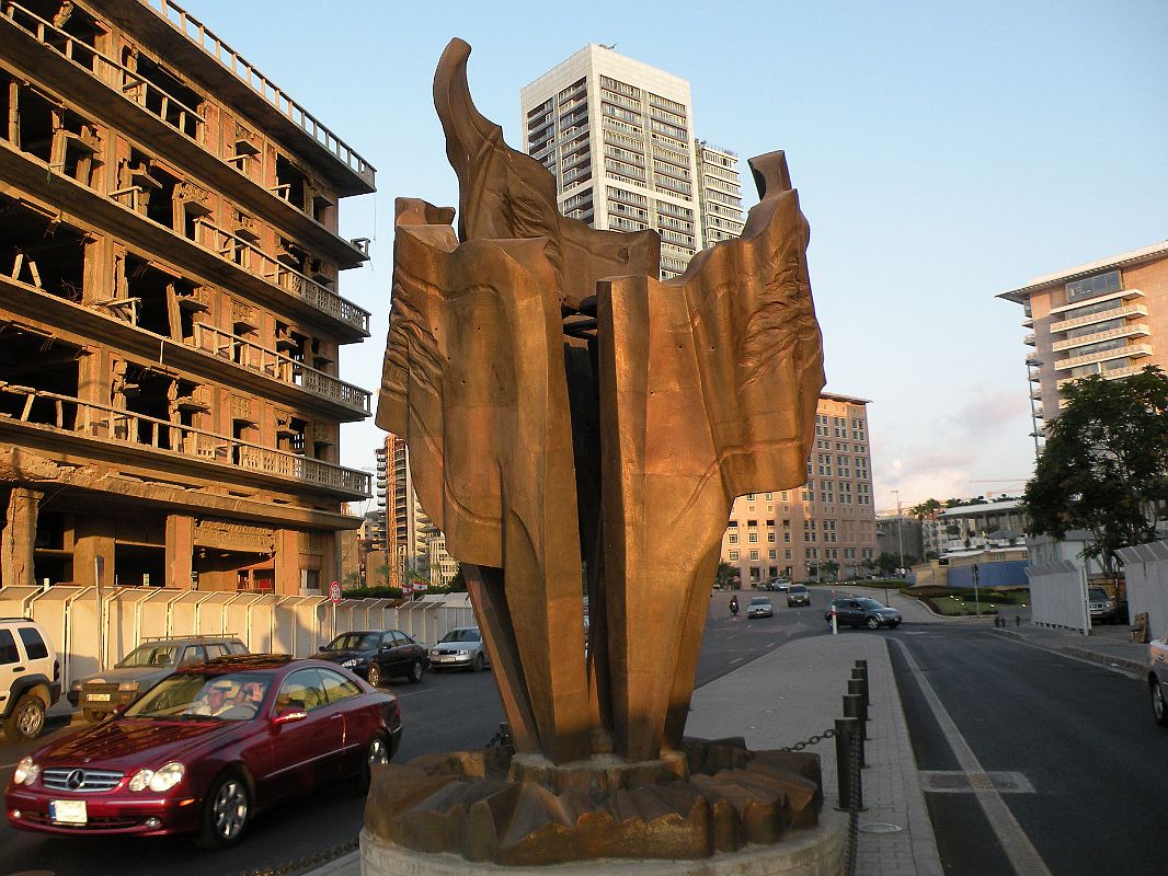 Beirut Corniche 10 A Sculpture Of A Flame Called The Torch Sits Next To The Bombed Out St Georges Hotel With Platinum Tower Behind 